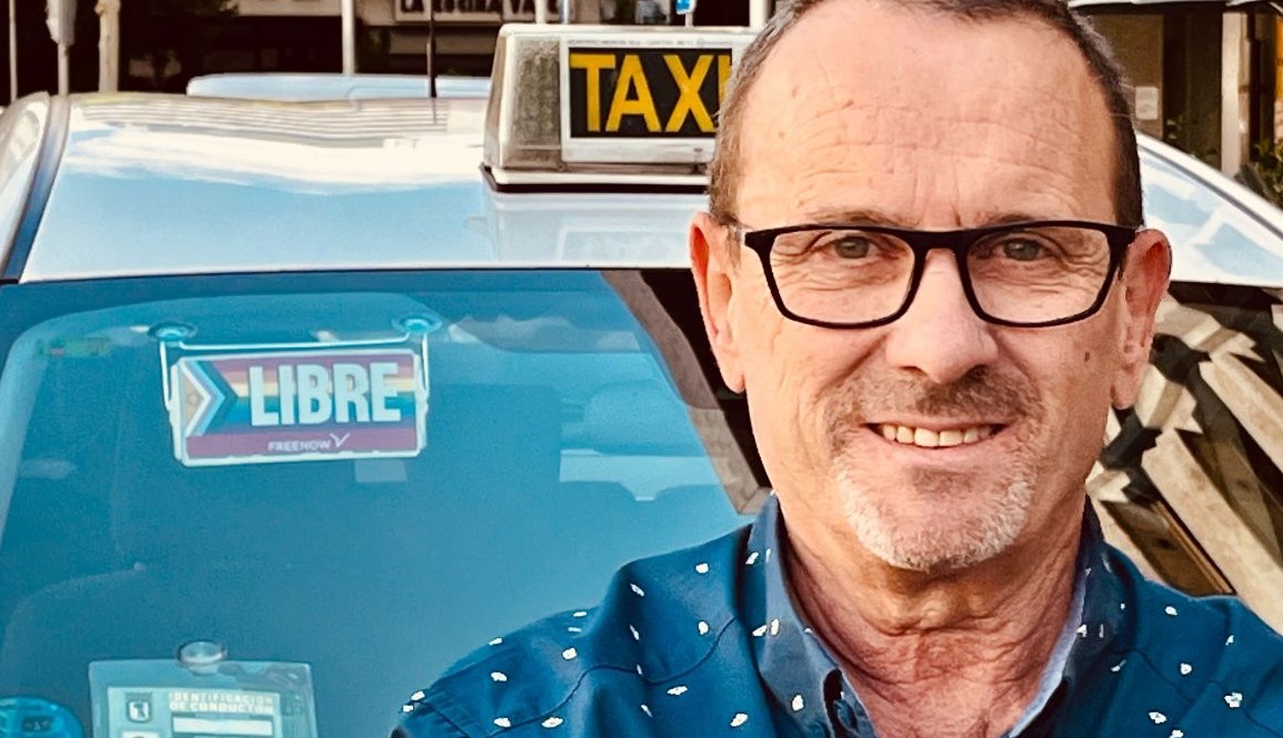taxista con el cartel de libre con la pegatina del orgullo