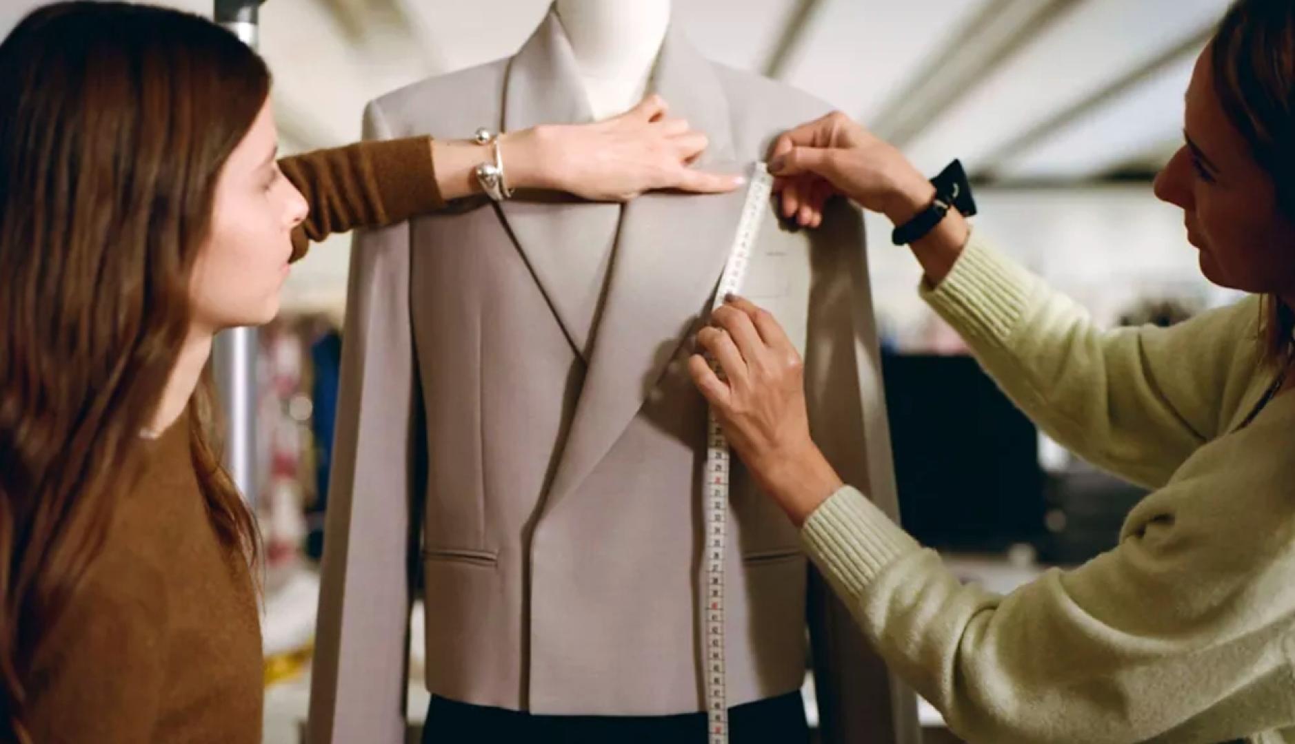 Dos mujeres tomando medidas a una americana colocada en un maniquí