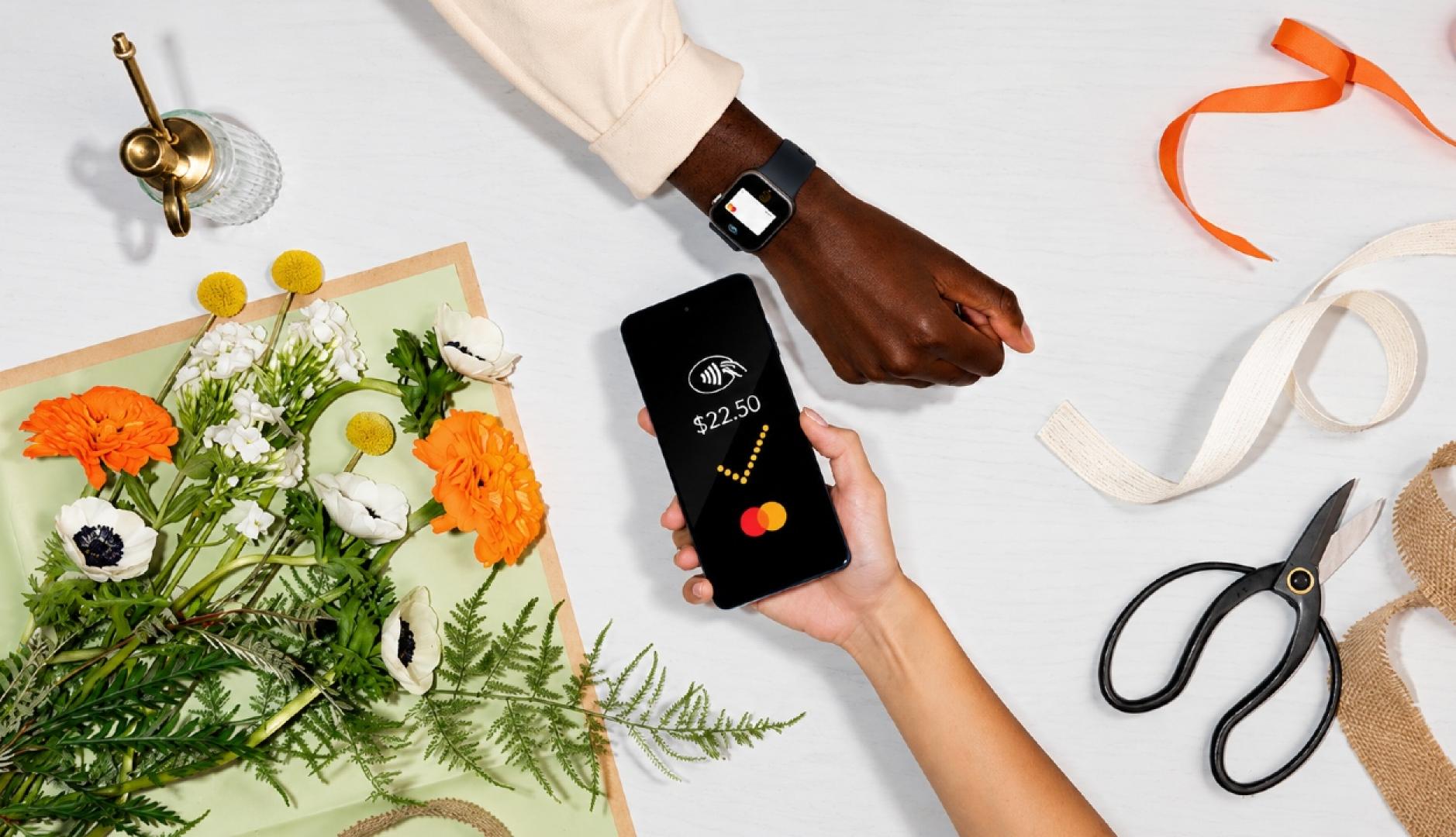 Una mano pagando con el teléfono a través de Mastercard