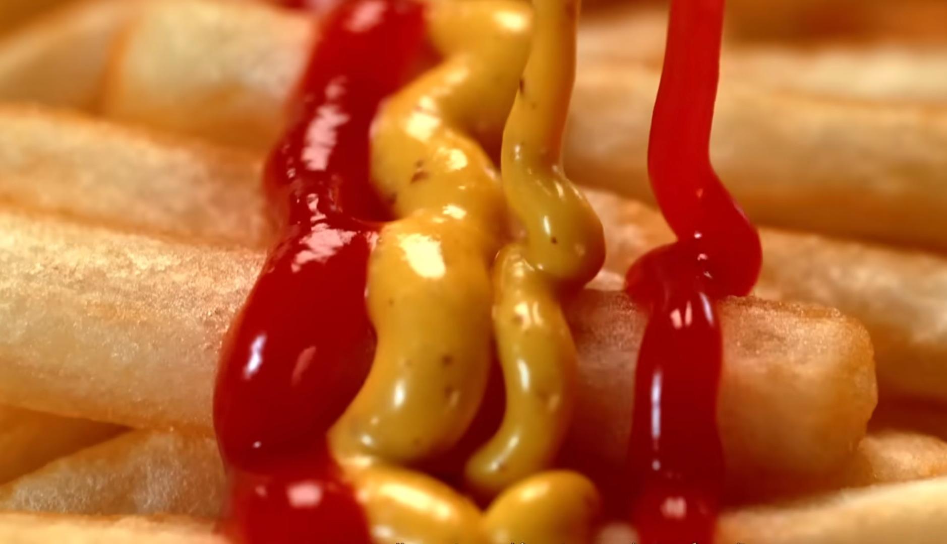 Mostaza y ketchup sobre patatas fritas formando bandera de España