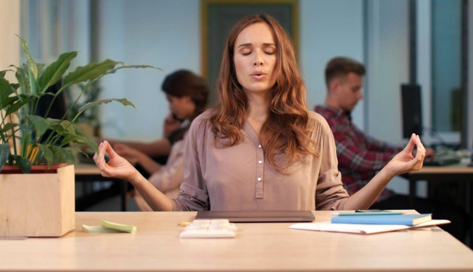 Una mujer con gesto de meditación en la oficina