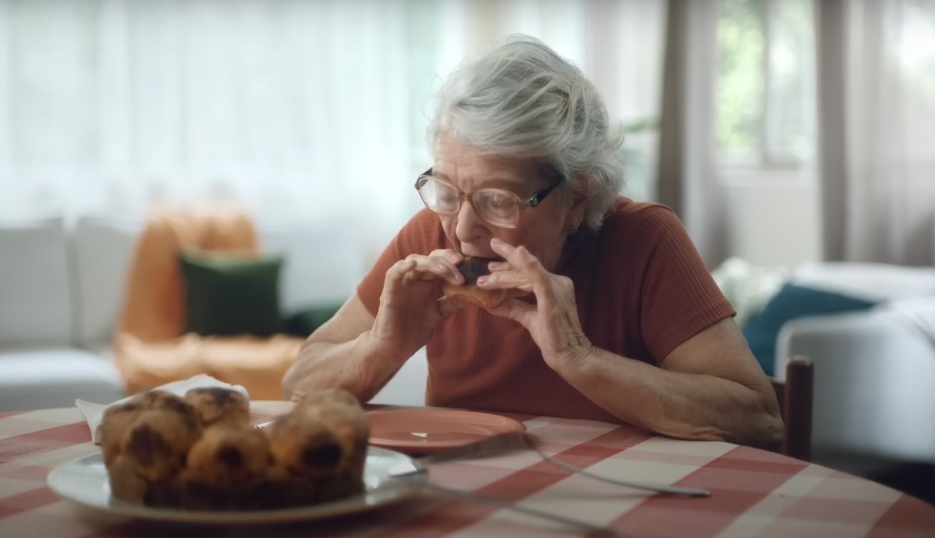 Mujer mayor come un pedazo de pastel con las manos