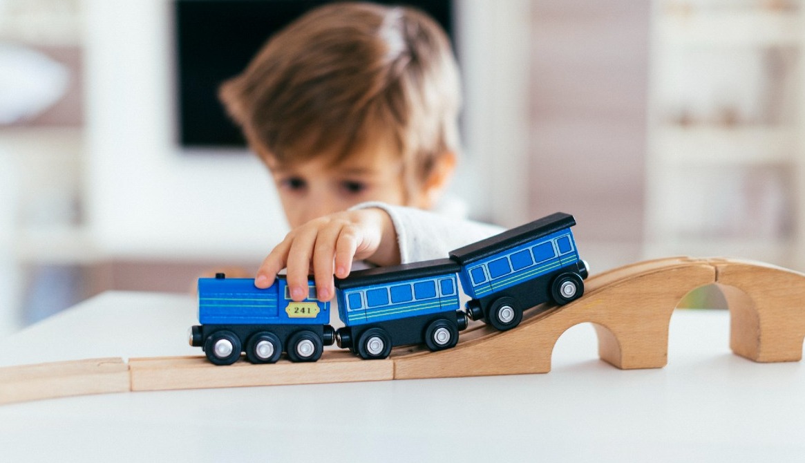 niño jugando con un trenecito