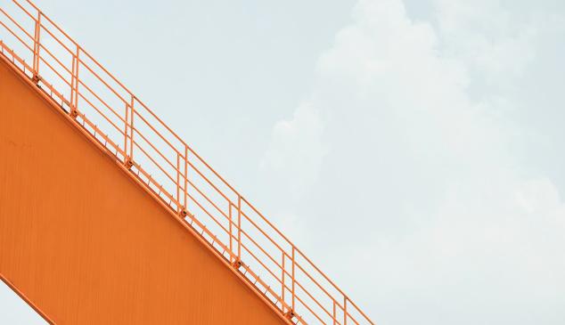 escalera de color naranja sobre cielo grisaceo. descenso del nueevo negocio de las agencias de medios