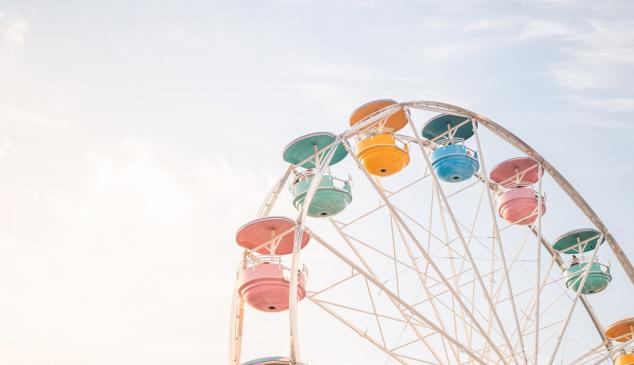 Atracción de noria con cabinas de colores sobre cielo azul para representar parques de atracciones