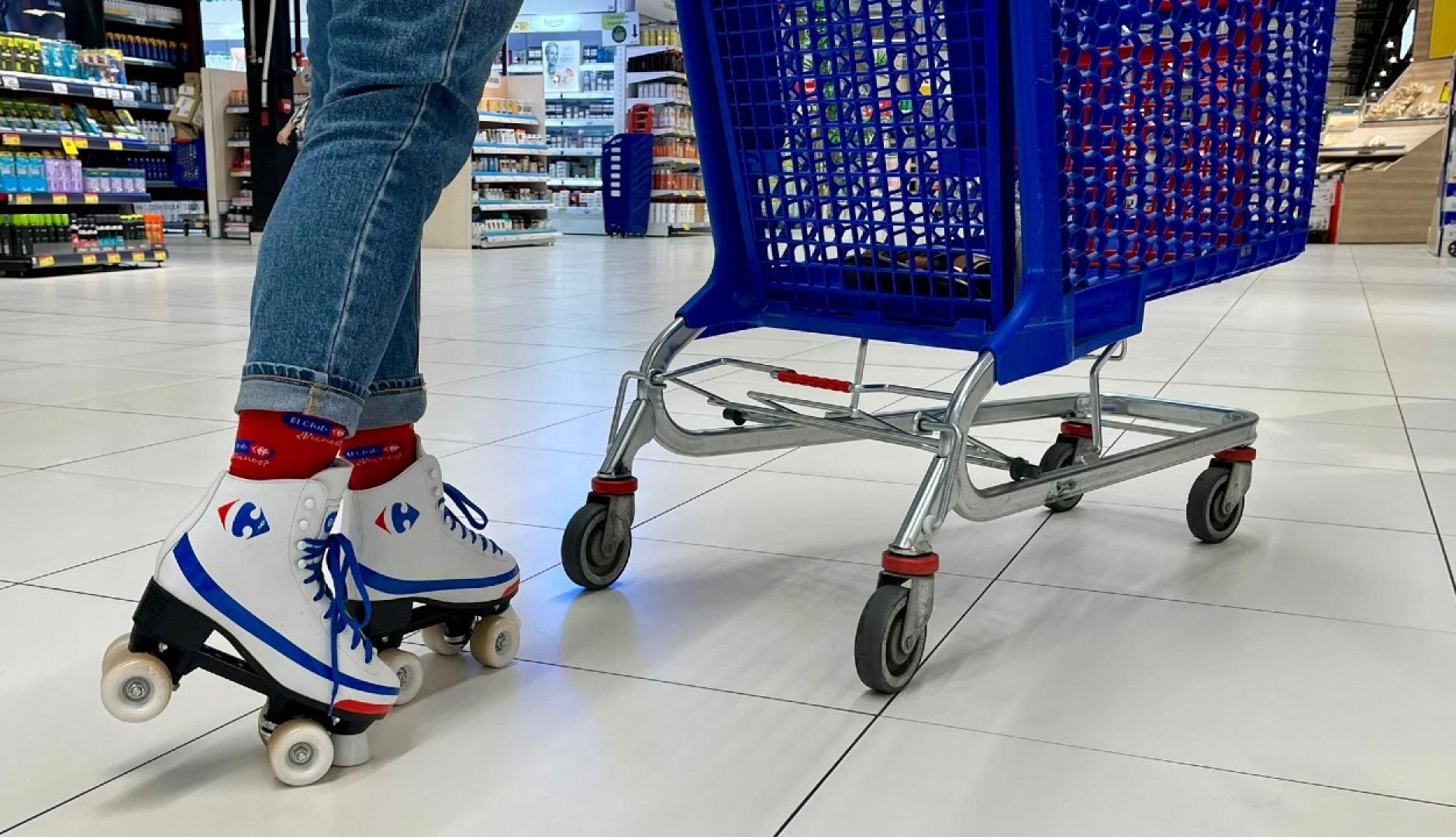 una persona con patines al lado de un carro de la compra en Carrefour
