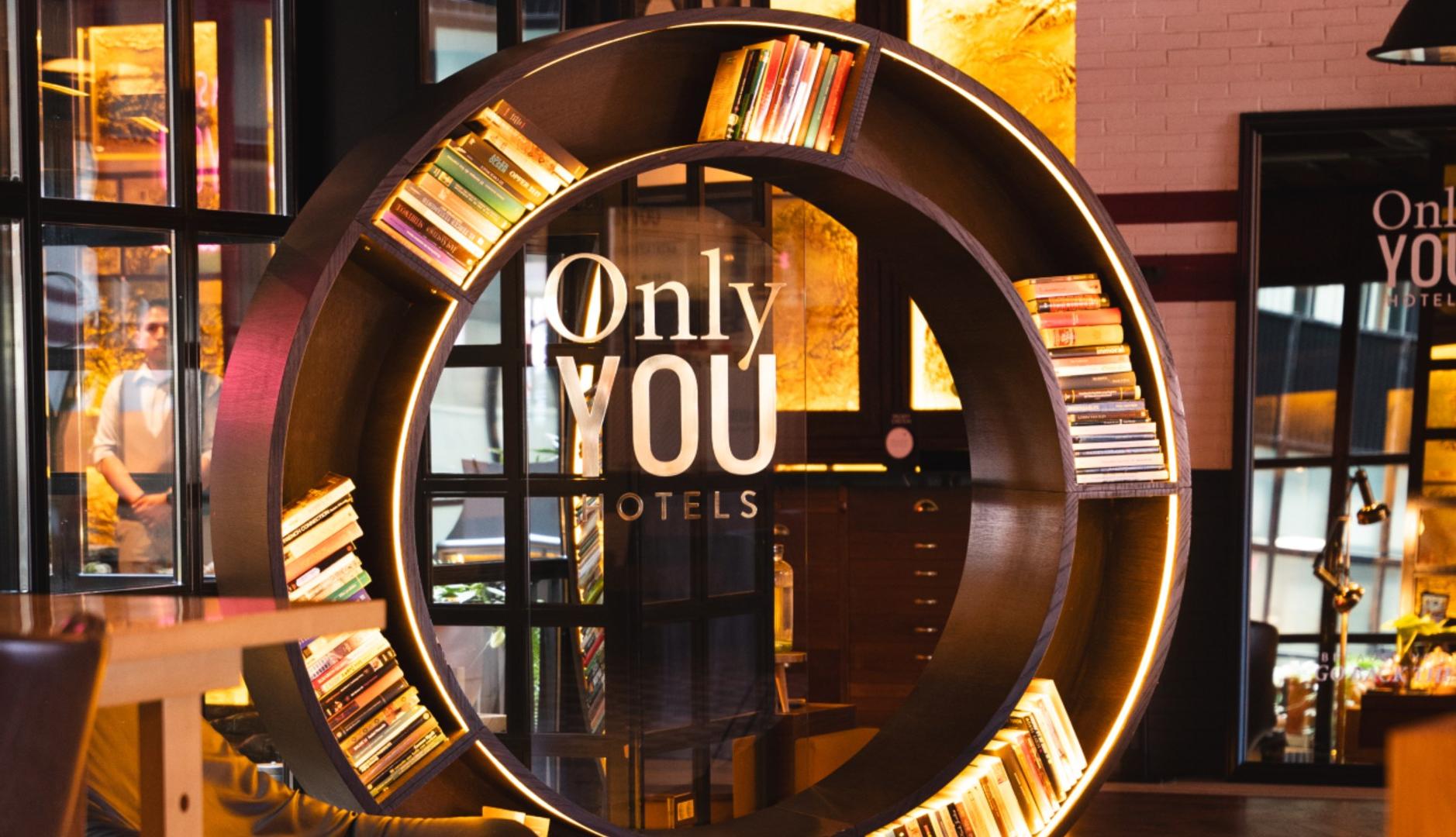 estantería de Only You Hotels, con forma circular y luces led integradas, en un espacio común de uno de sus hoteles.