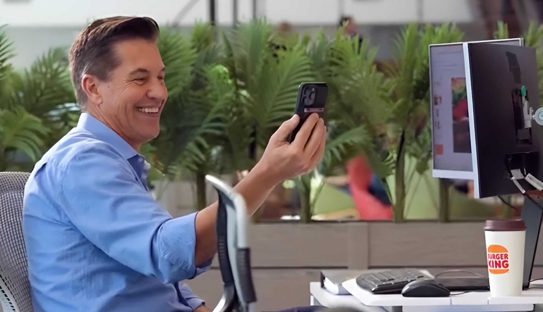 El presidente de Burger King haciendo una videollamada con el móvil en su mesa de trabajo