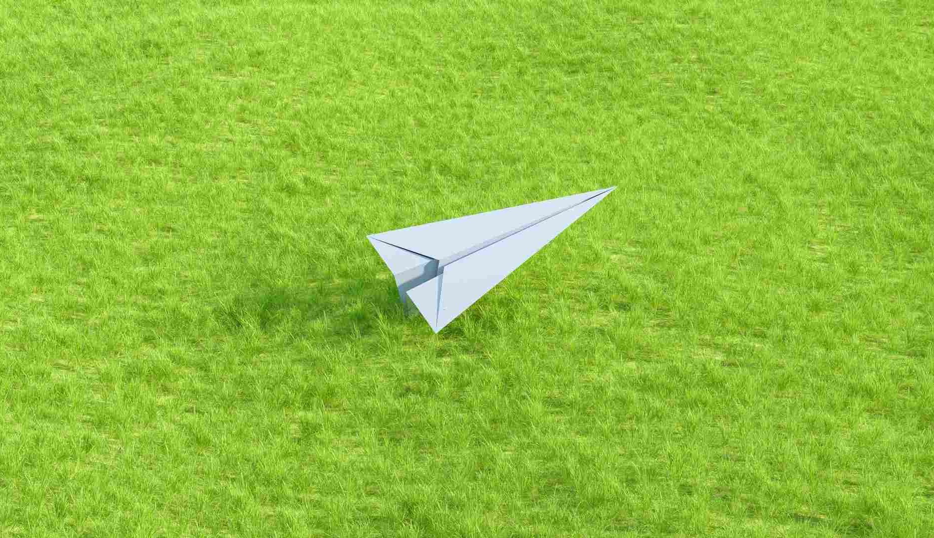 Avión de papel sobre hierba