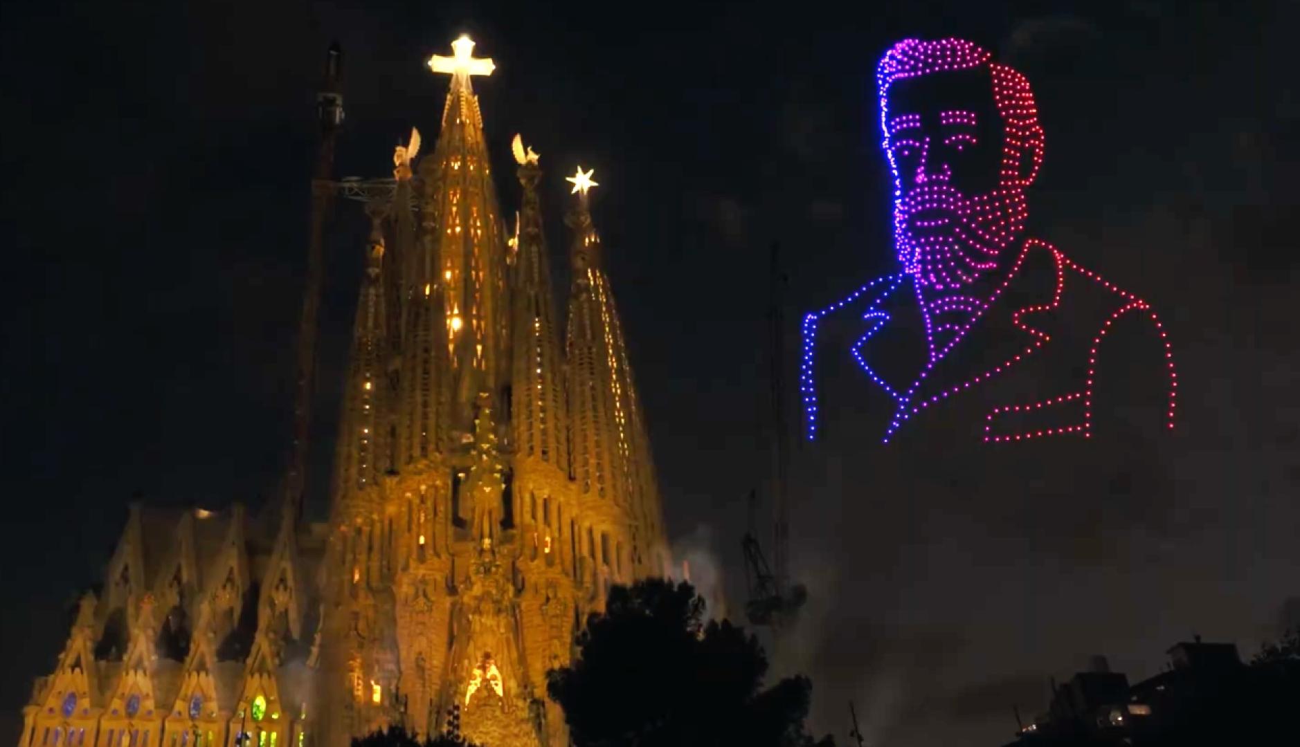 La Sagrada Familia iluminada y la imagen de Gaudí al lado hecha con drones