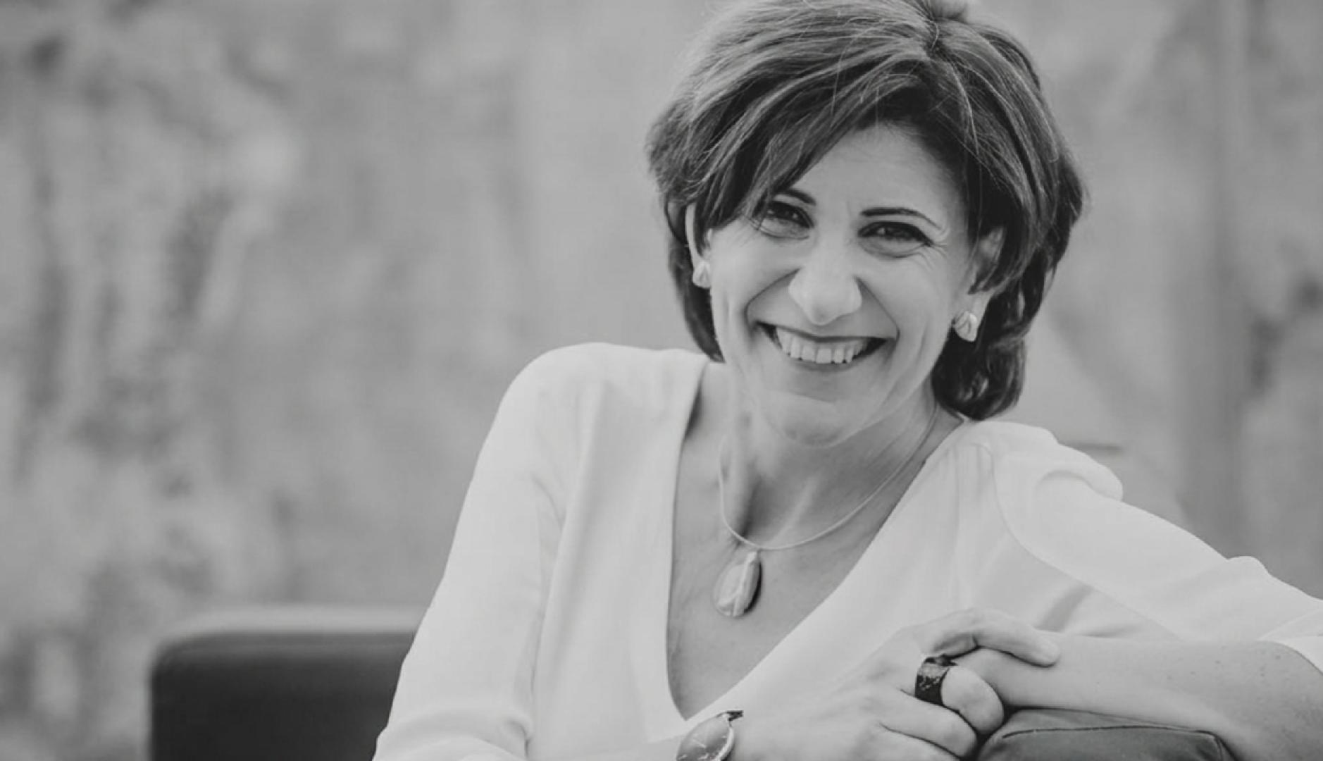 Foto en blanco y negro de Sara Blázquez sonriendo sentada en una butaca