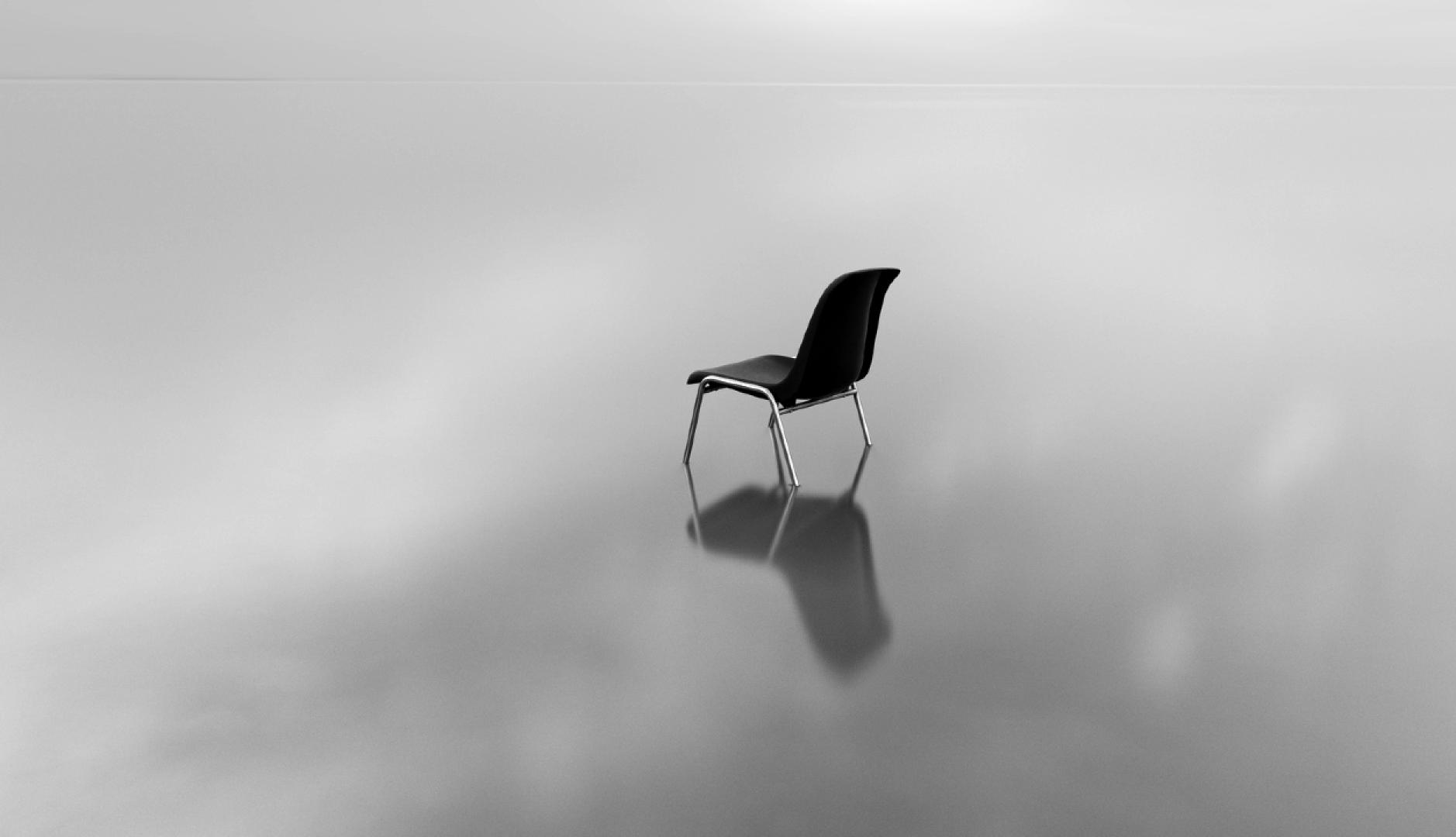 Una silla en un paisaje vacío en blanco y negro
