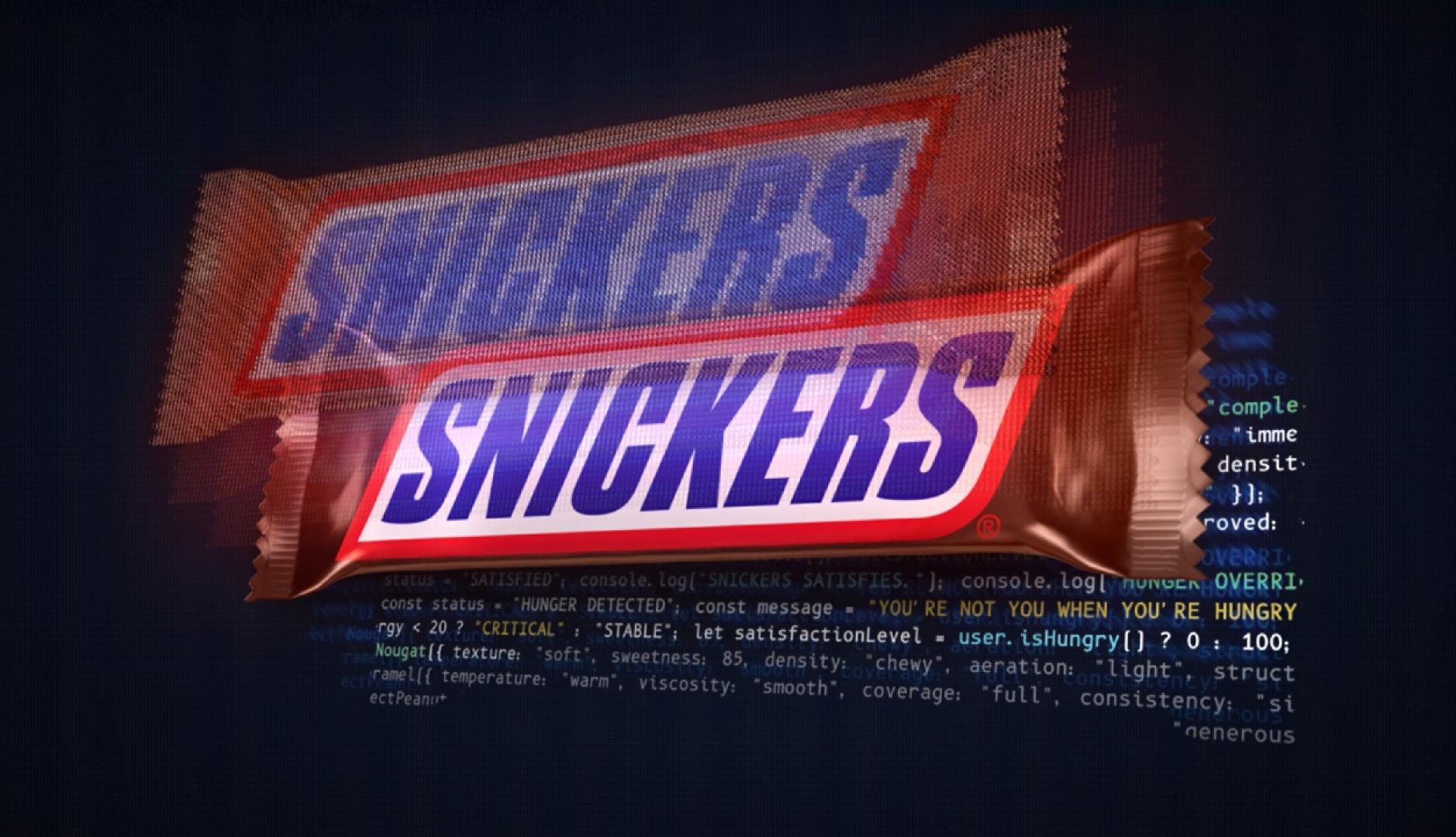 Una barra de chocolatina Snickers sobre un fondo de código de programación