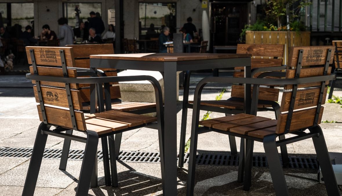conjunto de sillas y mesa en una terraza de un bar con madera reciclada