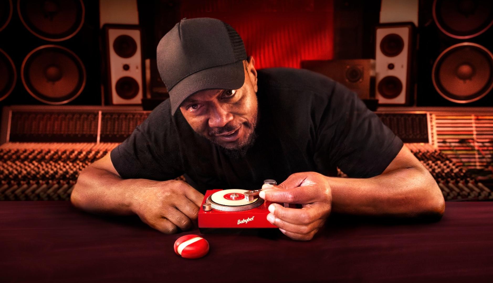 Timbaland posando junto al tocadiscos mini de babybel
