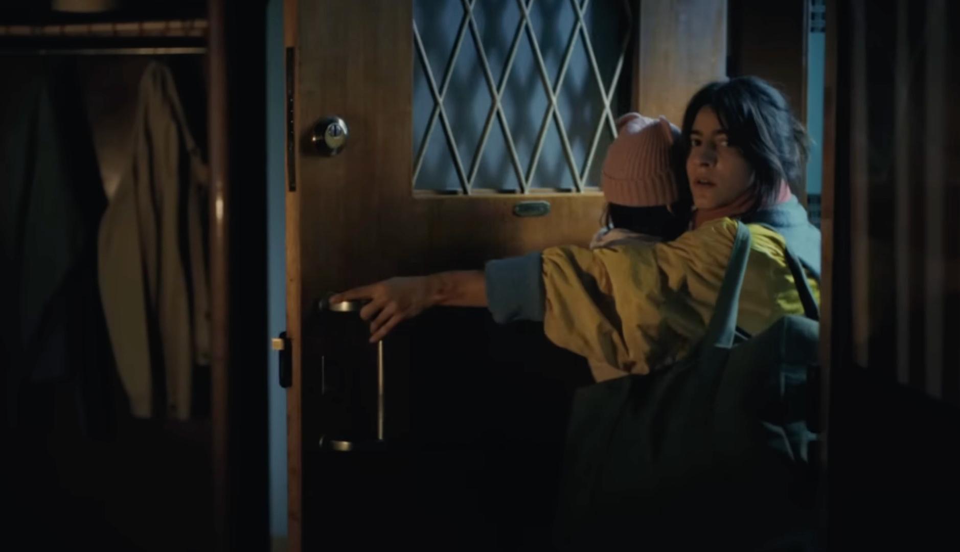 Mujer con un niño en brazos se va de casa