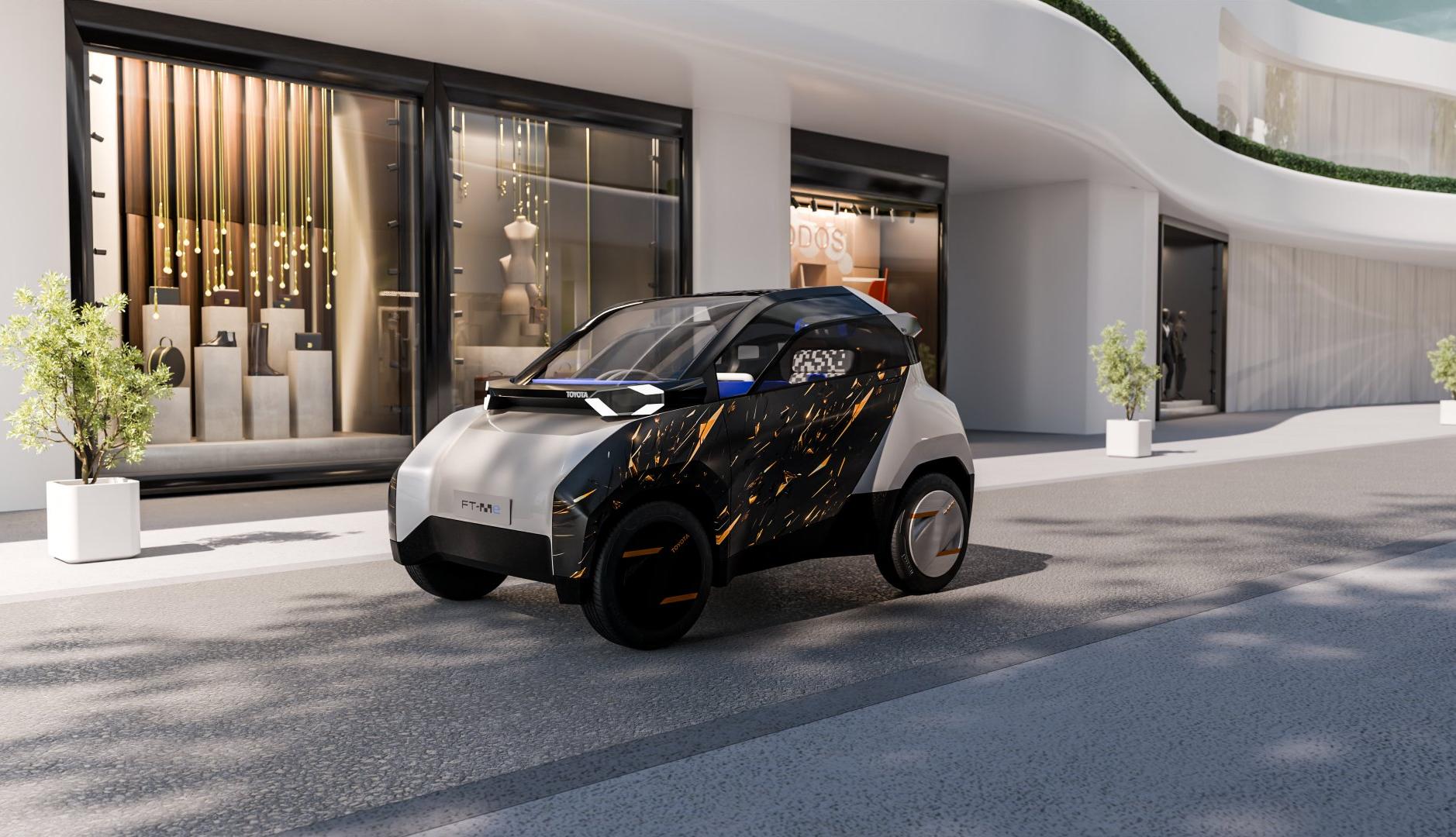 Concept art del coche Toyota FT-Me frente a un edificio moderno.
