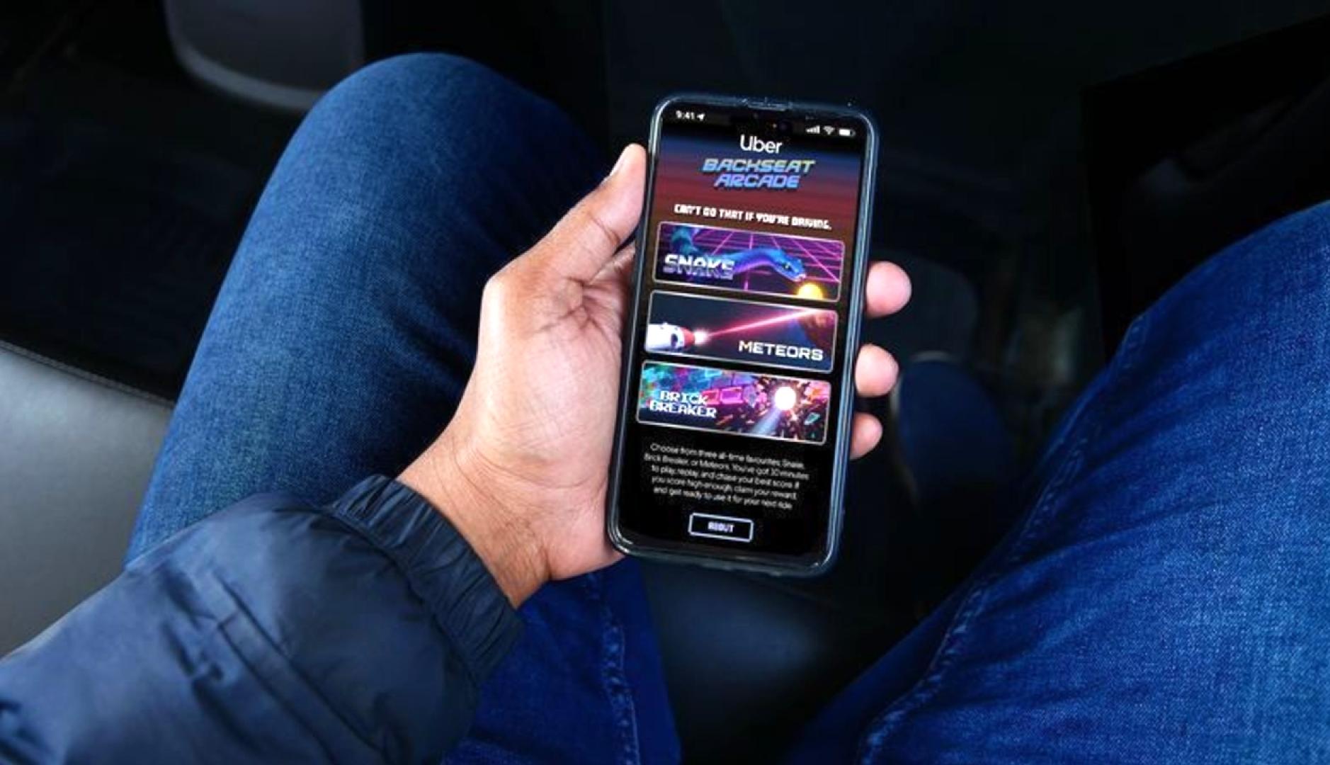 Un viajero sosteniendo el smartphone con la interfaz del juego de arcade