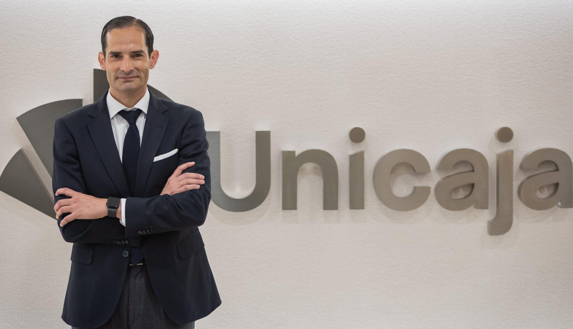 Gonzalo Saiz ante el logo de Unicaja