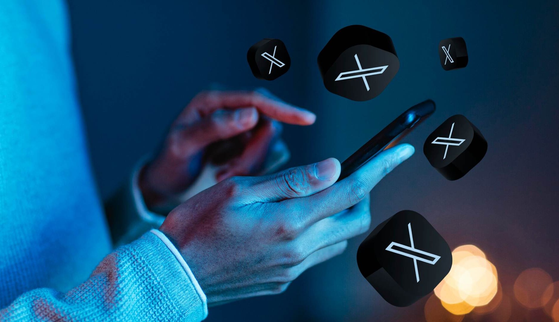 Manos de hombre sujetando un móvil con iconos de X alrededor