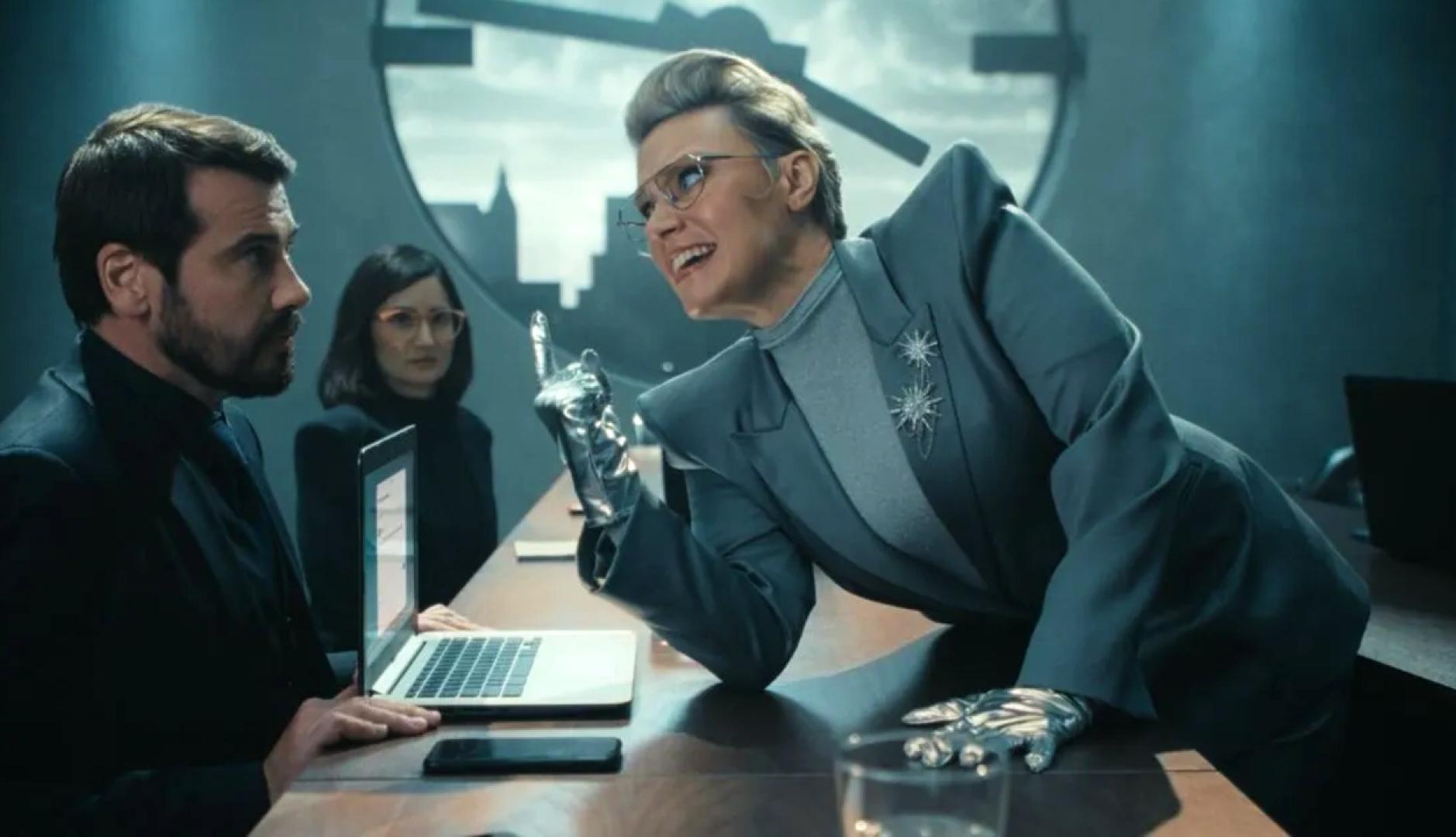 La actriz Kate McKinnon subida en una mesa amenazando a un empleado