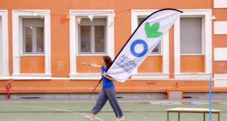 Mujer camina sosteniendo una bandera de Acción Contra el Hambre