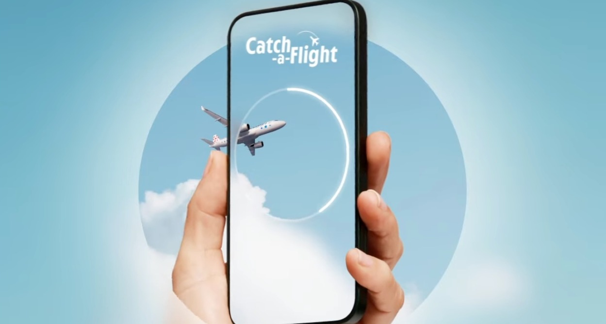 Una mano sostiene un móvil mientras un avión cruza la pantalla