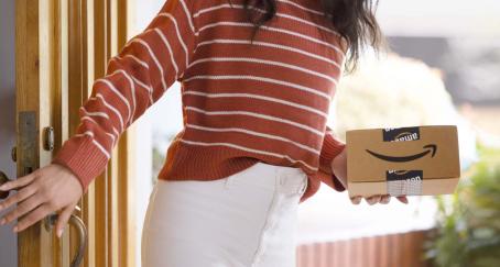 Chica con un paquete de Amazon en la mano