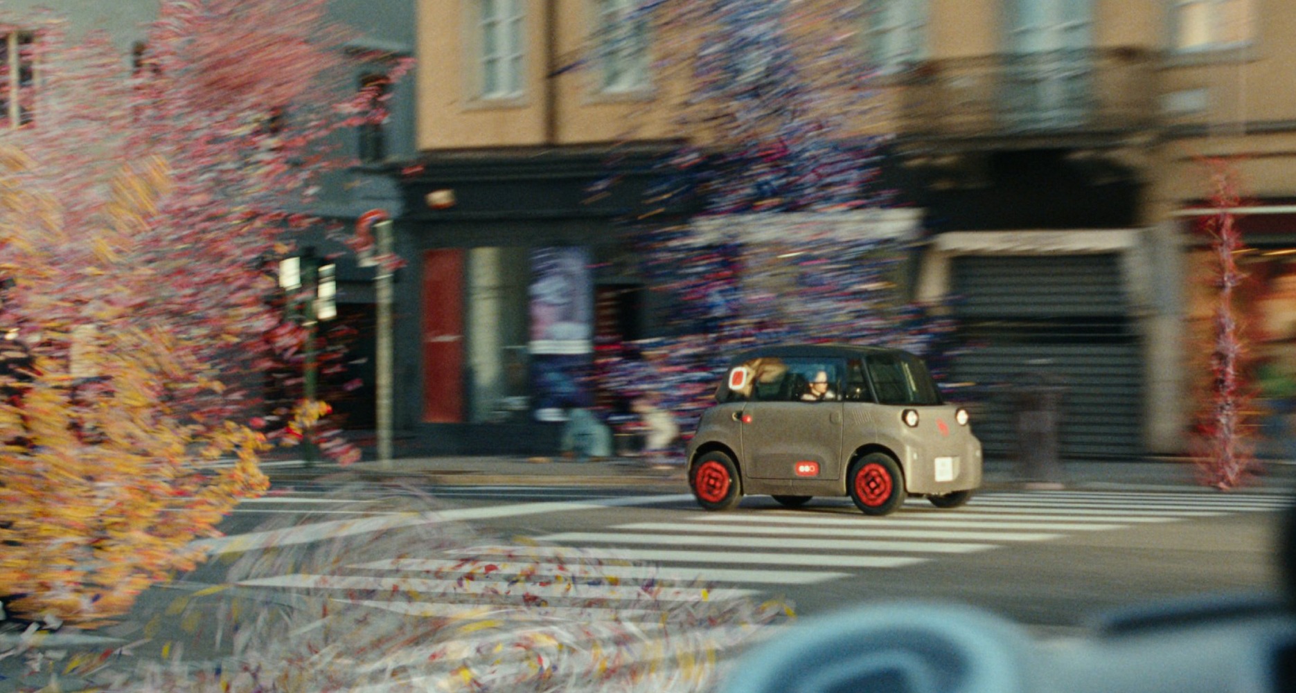 Un Citroën Ami por la ciudad circulando entre confeti