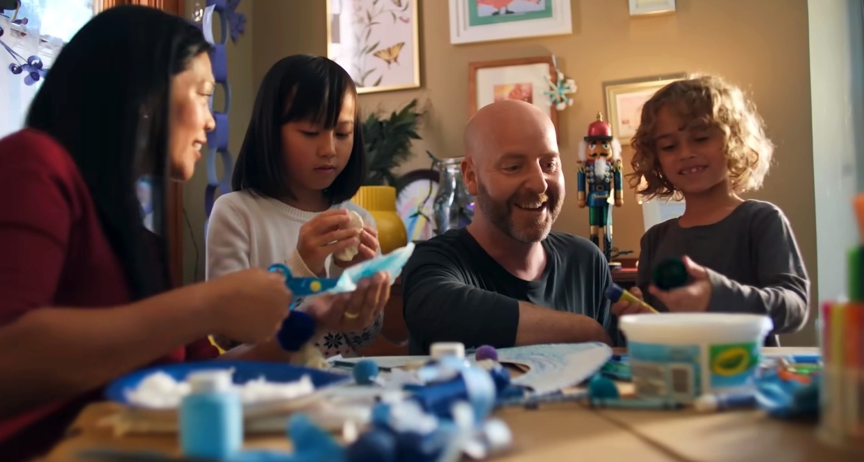 La familia del anuncio haciendo manualidades navideñas en colores azules