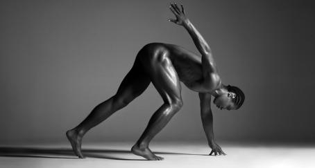 Un atleta negro desnudo como si fuera a salir a correr una carrera