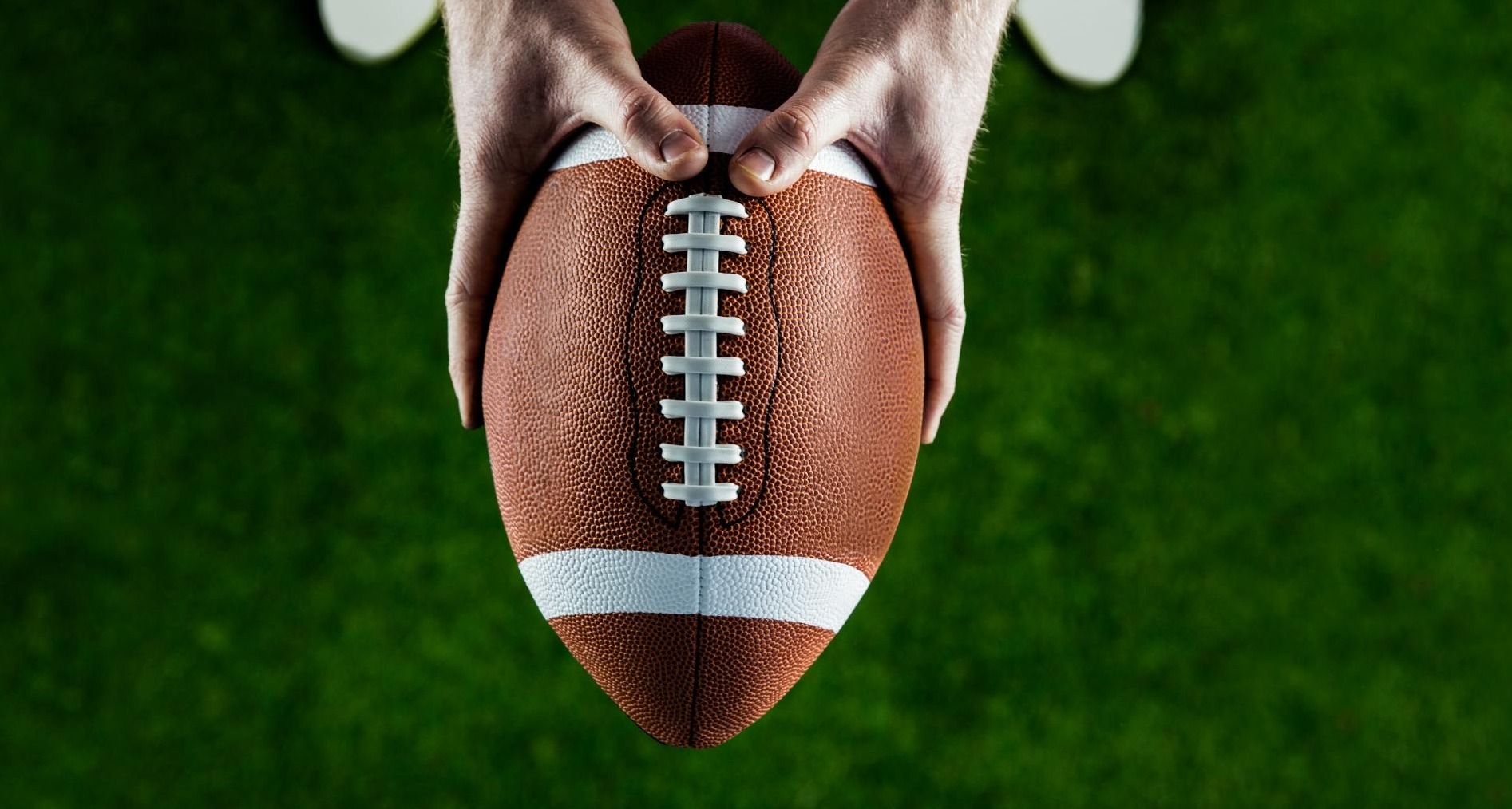 Manos sujetando un balón de rugby