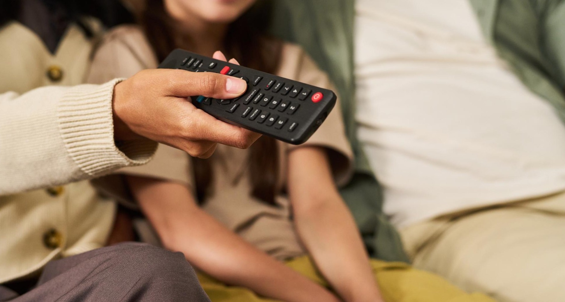 Mujer sujeta un mando de televisión
