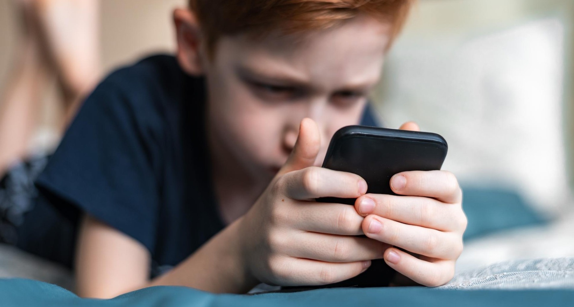 Niño mirando un teléfono móvil