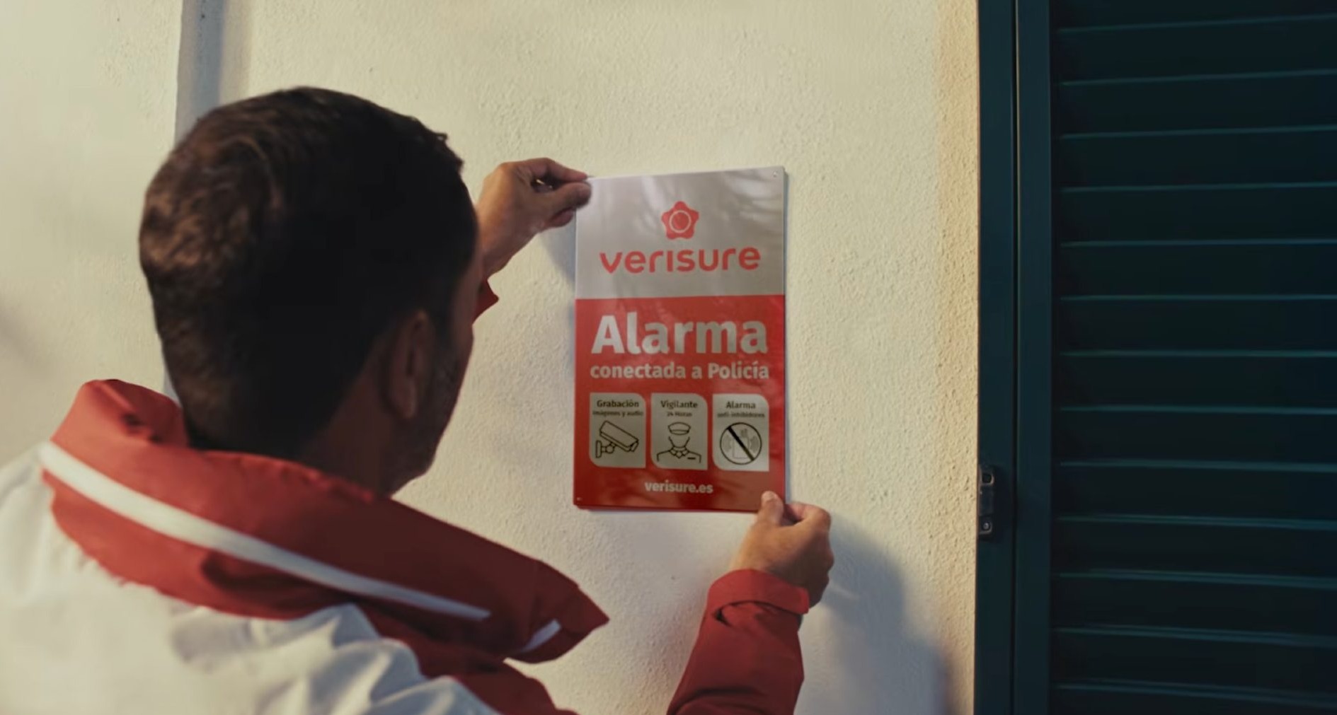 Hombre colgando un cartel de Verisure