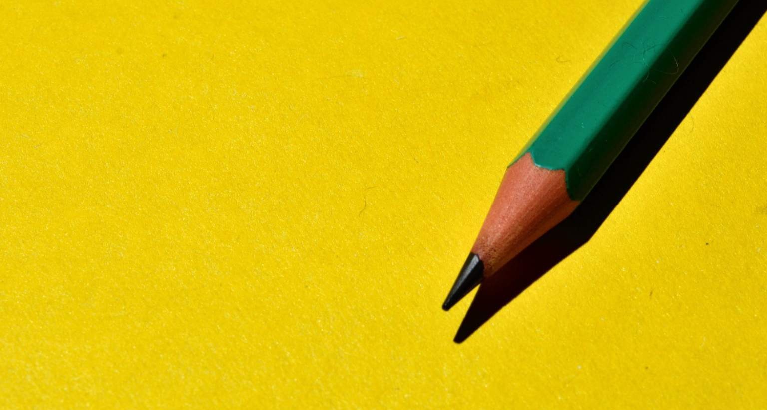 Lápiz verde sobre fondo amarillo