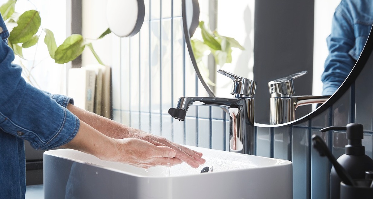 persona lavándose las manos en un lavabo