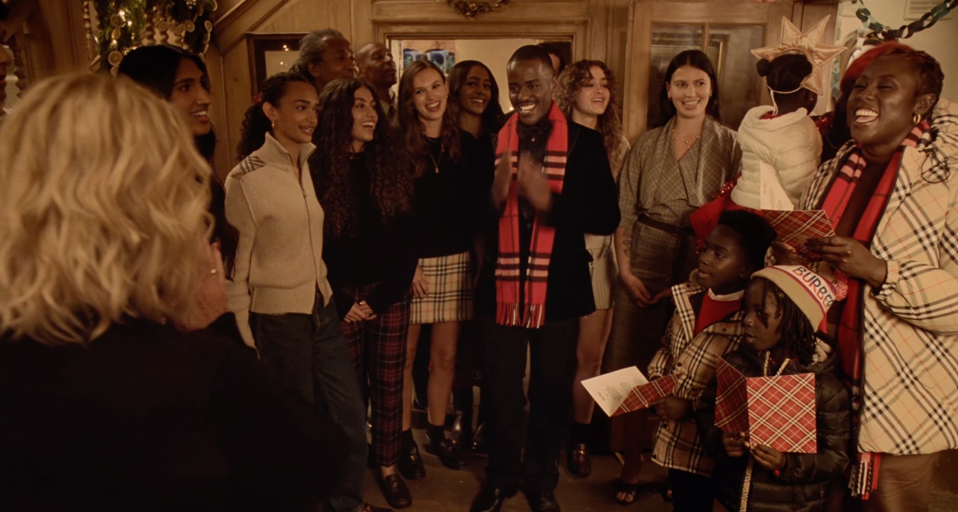 Grupo de personas cantan villancicos en el anuncio de Navidad de Burberry