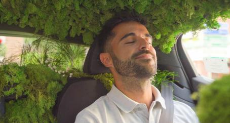Chico dentro de un coche adornado como un bosque