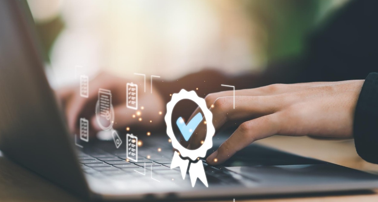 Una manos sobre un teclado y un sello de certificación sobreimpreso