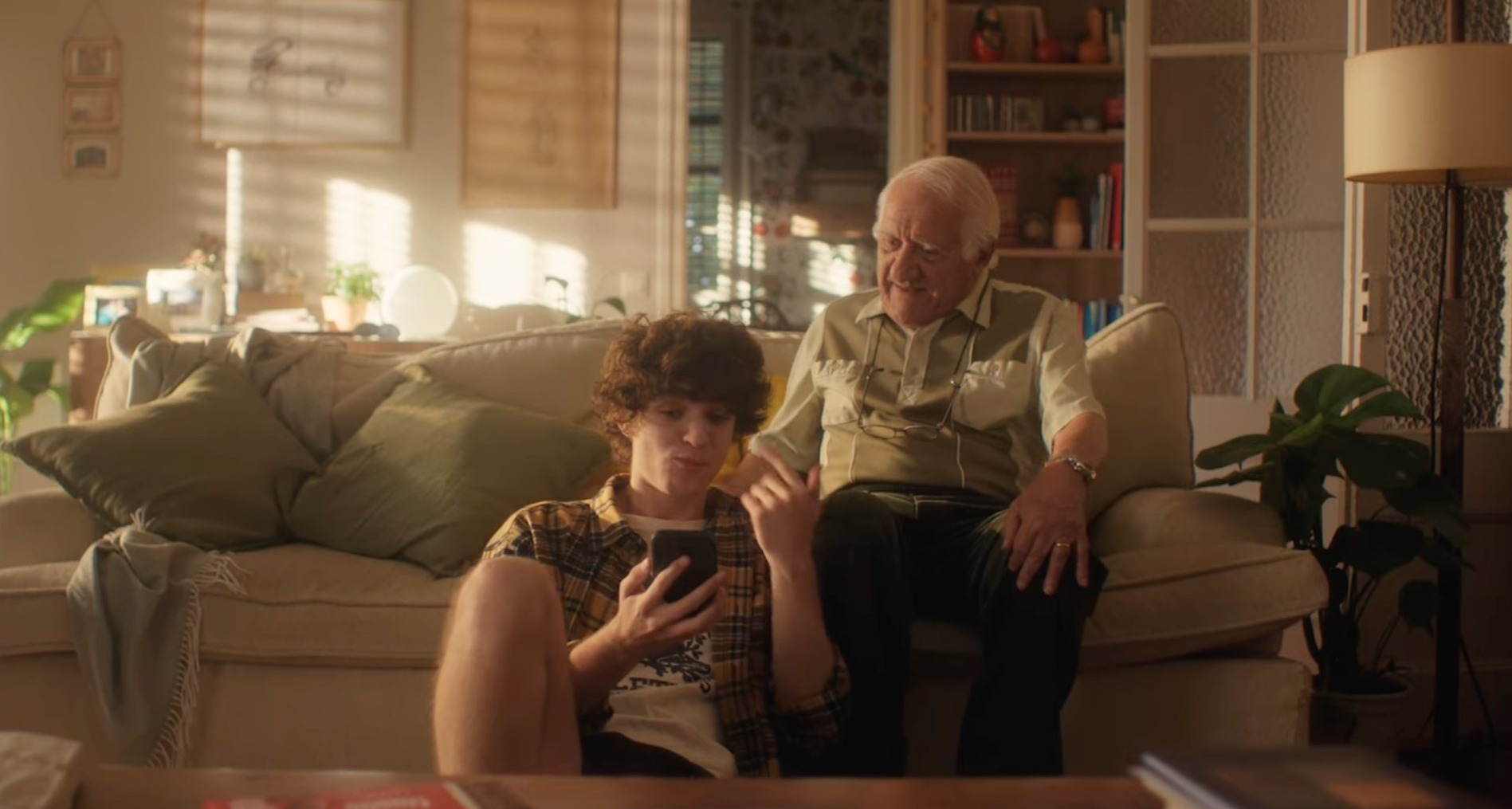 Un abuelo y un nieto sentados en el sofá hablando