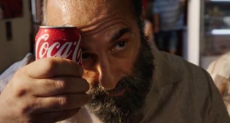 Un hombre refresca su frente con una lata de Coca-Cola