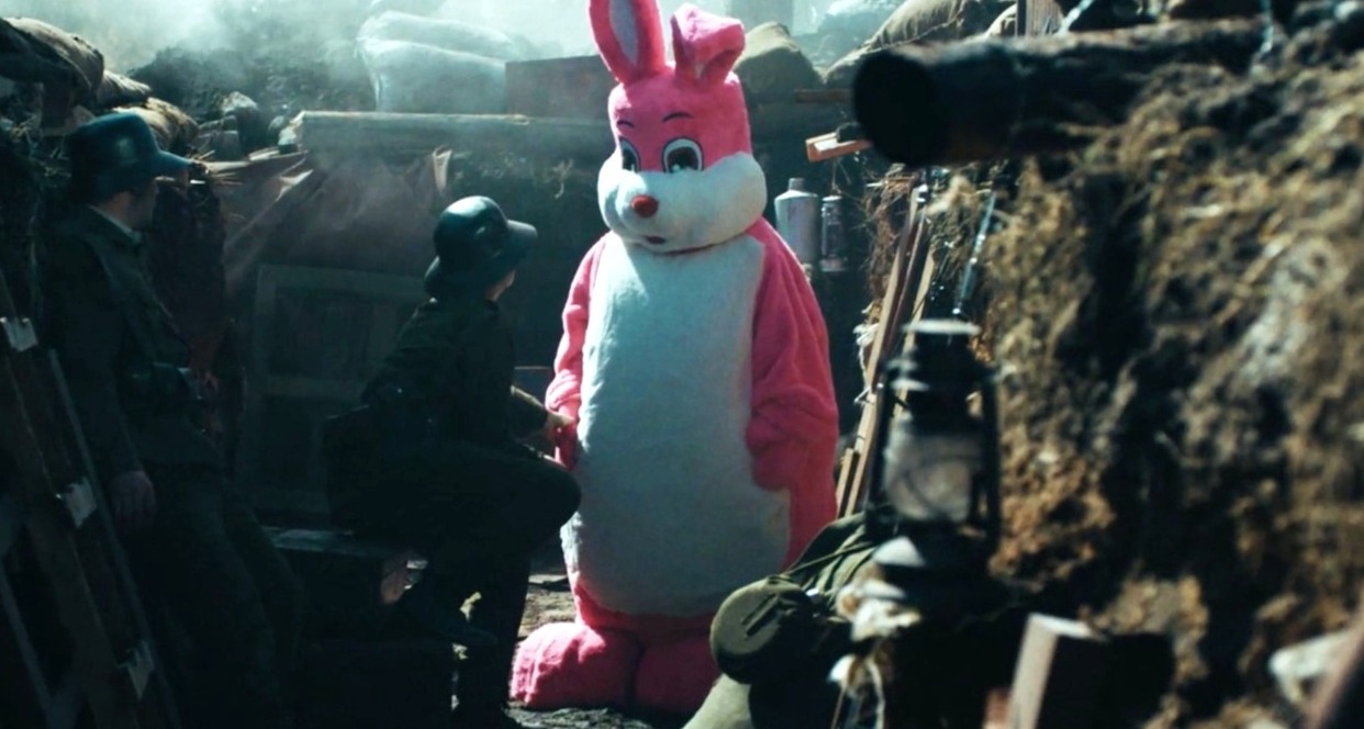 Un conejo rosa, como el de Duracell, en una trinchera bélica con soldados y armas