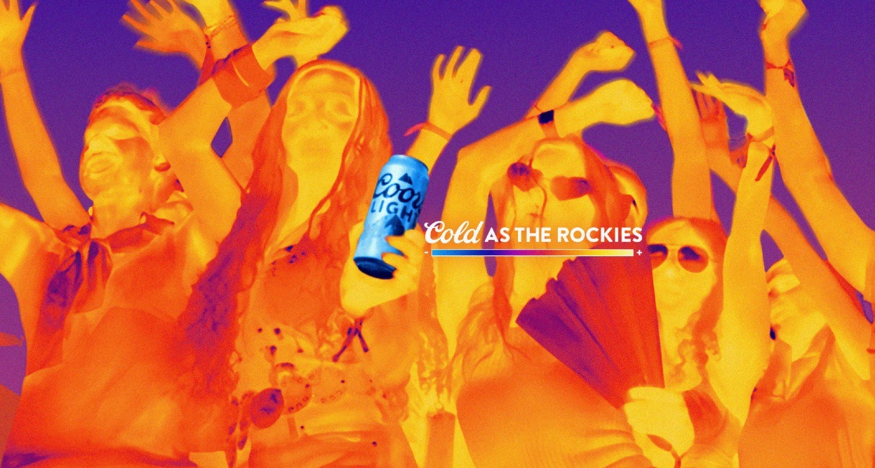 Unas personas bailando captadas con cámara térmica en tonos naranjas y la lata de Coors se mantiene en azul