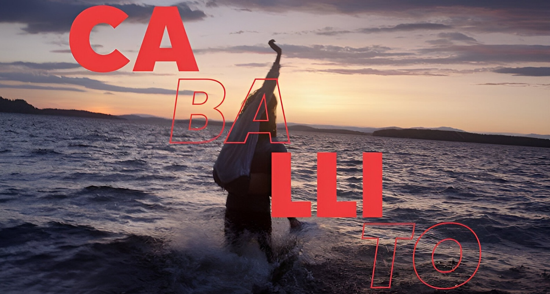 Una persona subida encima de otra en una playa al atardecer