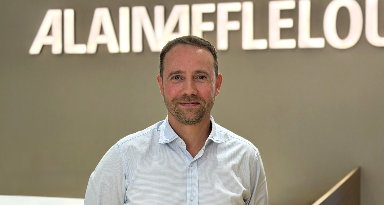 Un plano medio de Jon Mielgo y el logotipo de Alain Afflelou detrás