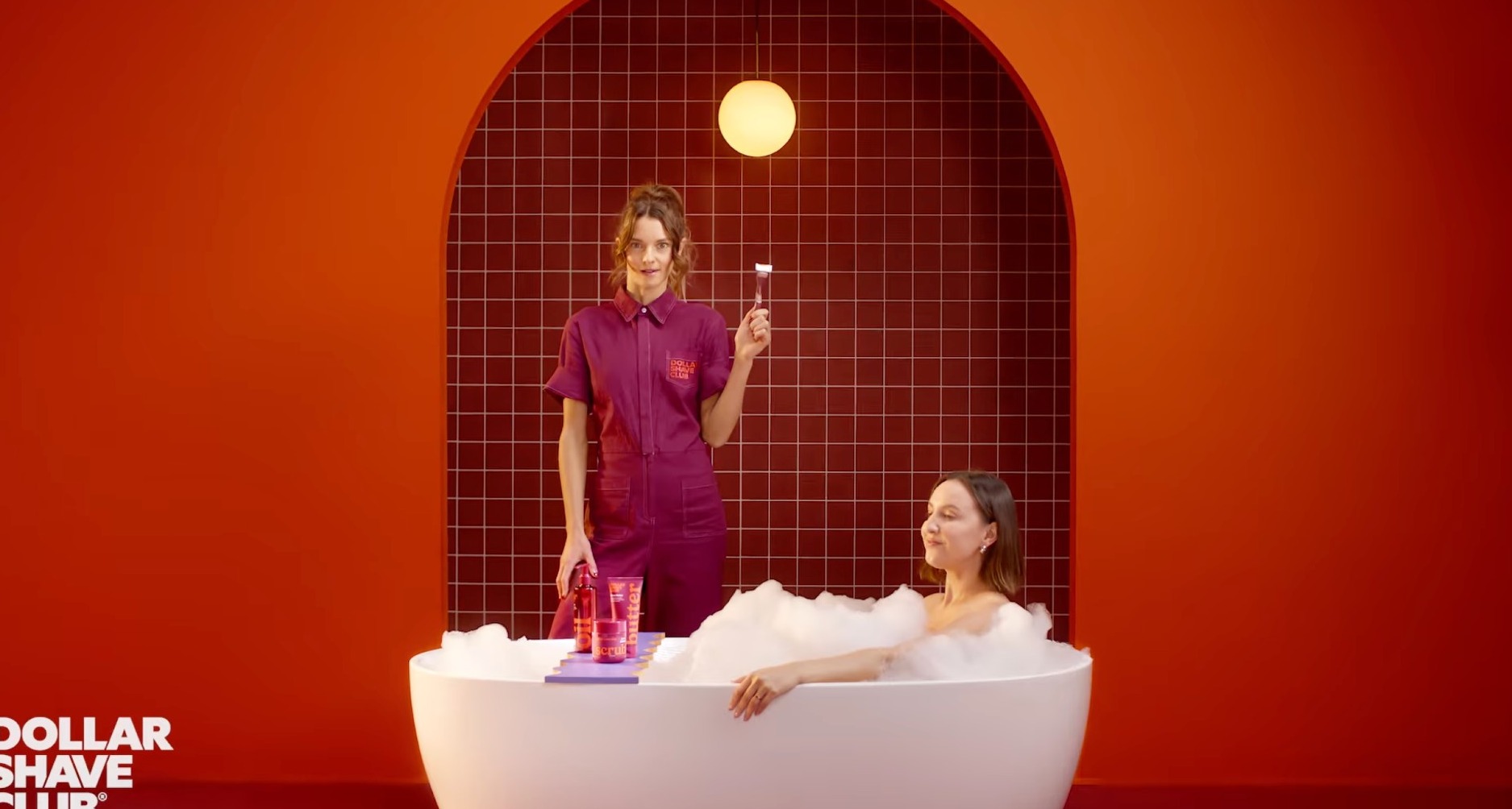 Una mujer en la bañera ante fondo rojo