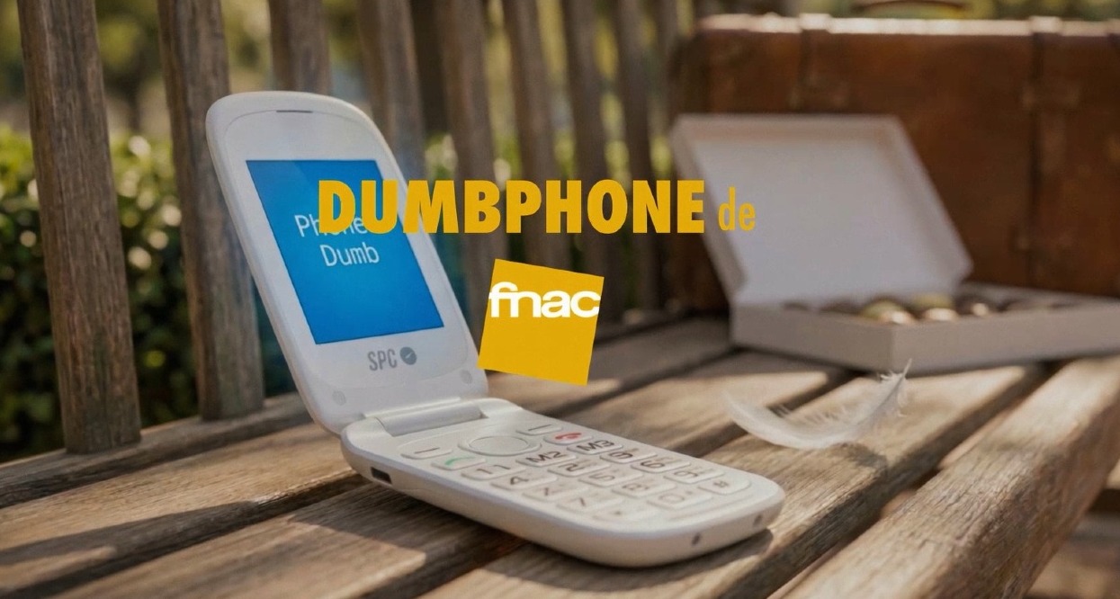 El dumbphone de Fnac abierto sobre un banco de madera en la calle