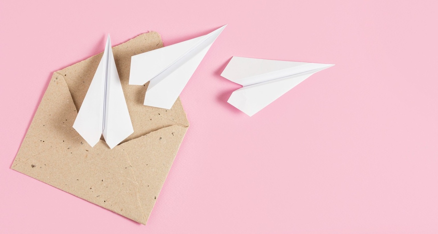 Imagen de unos aviones de papel saliendo de un sobre