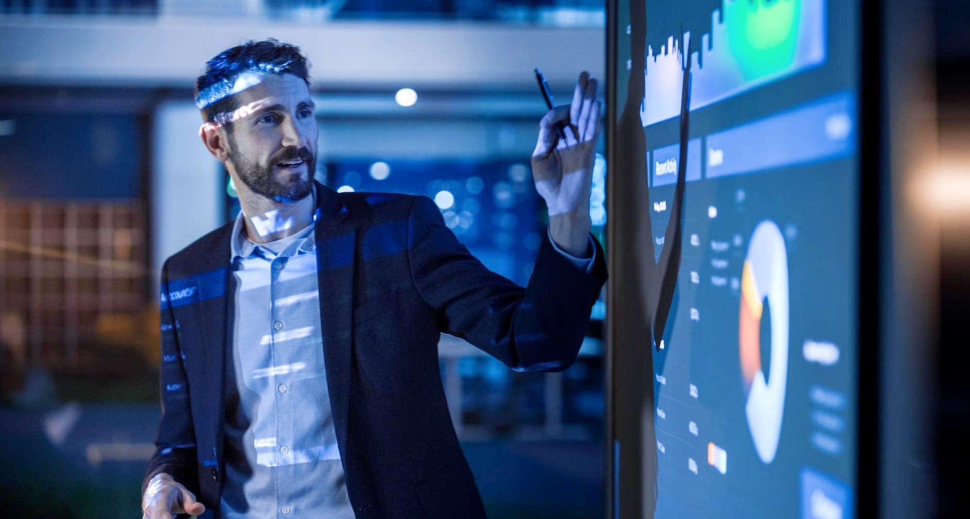 Un hombre mostrando datos y graficos en una pantalla difgital